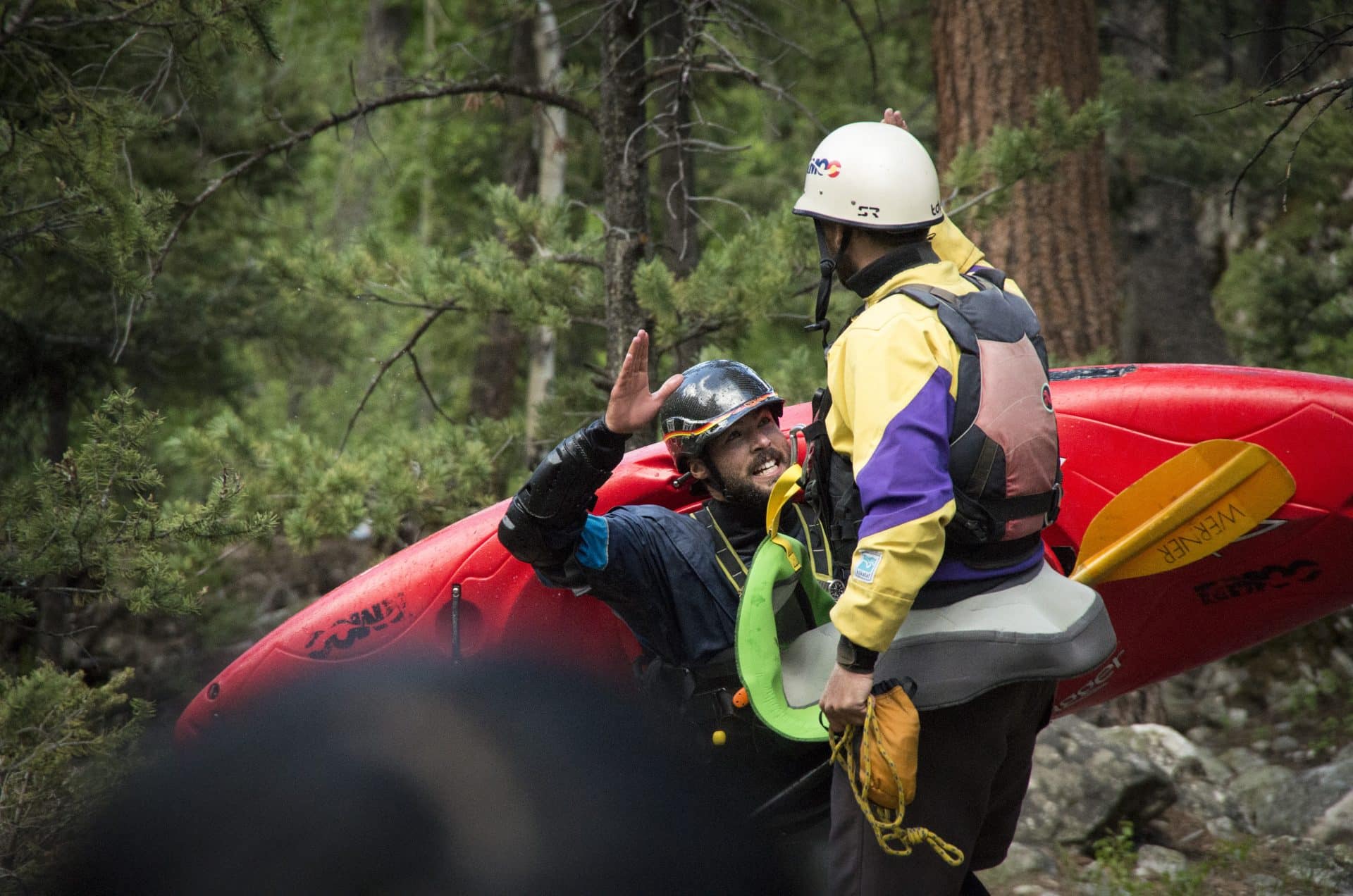 two people talking with a kayak