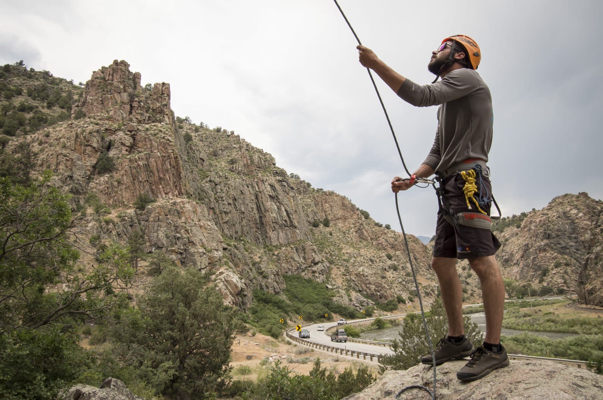 Man in rock climbing gear belaying