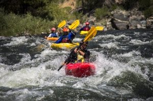 Group kayaking through a small rapid