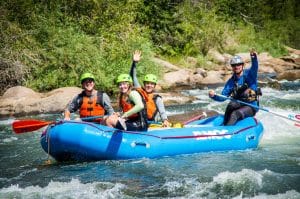 group laughing and waving from a raft