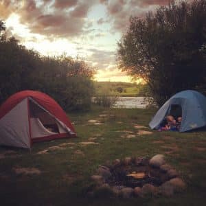 Two tents around a campfire