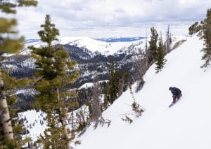 Person on side of snowy, steep mountain