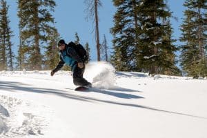 Snow surfing down powder