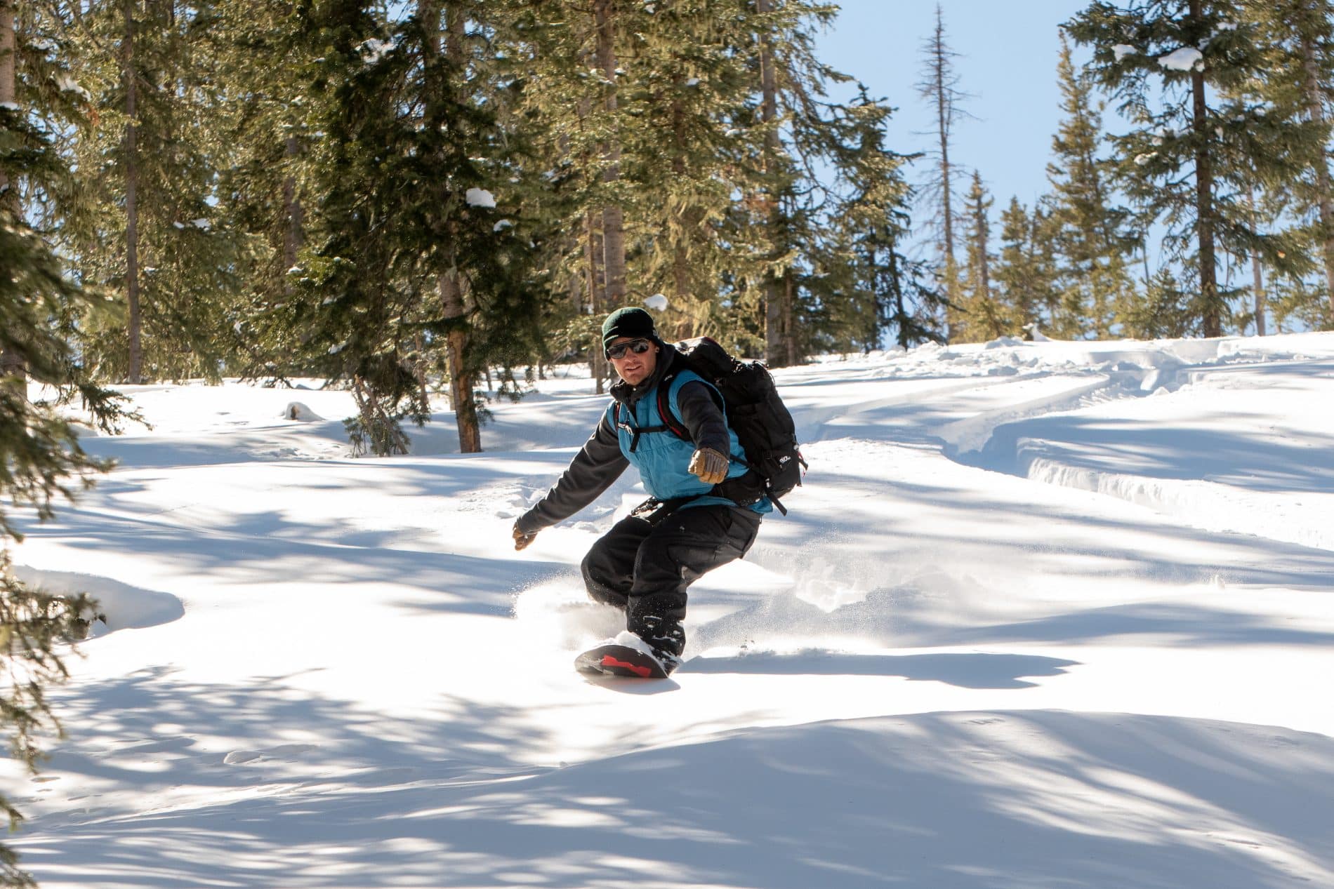 Snowboarder carving through fresh powder.