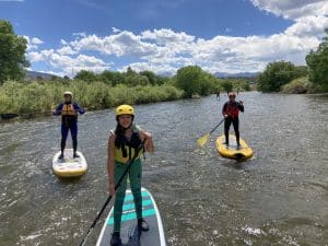 Three kids paddleboarding