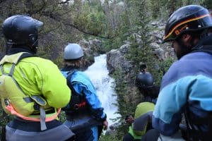 team looking over rushing river