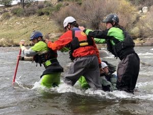 Group holding each other steady in the river