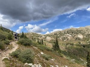 wide mountain landscape with a trail and a hiker with a bike