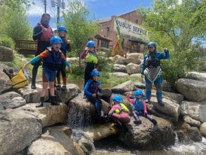 Group of kids by the river wearing safety equipment