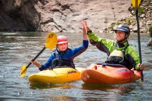 youth kayaker and guide high fiving